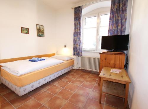 Schlafzimmer mit einem Bett, einem TV und einem Fenster in der Unterkunft Gasthof Adler in Frick