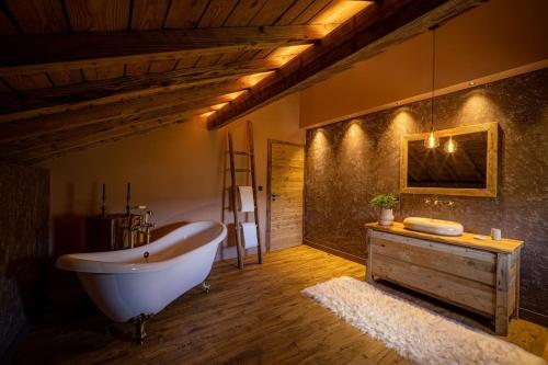 baño grande con bañera y suelo de madera. en Le 11 des Bouchaux, Gîte d'exception en La Bresse