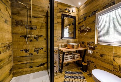 y baño de madera con ducha y lavamanos. en Greenwood 84, en Kelemen