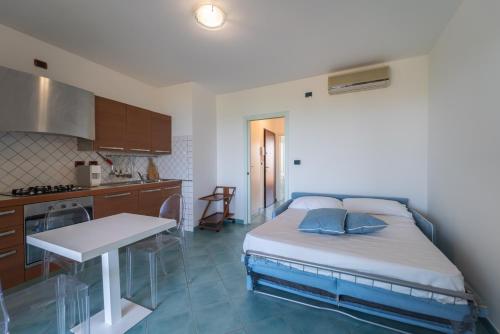 a bedroom with a bed and a table in a kitchen at Pepigall vista mare in Alghero