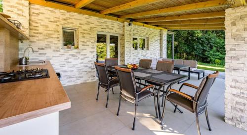 Una cocina y un comedor con mesa y sillas. en Greenwood 84, en Kelemen