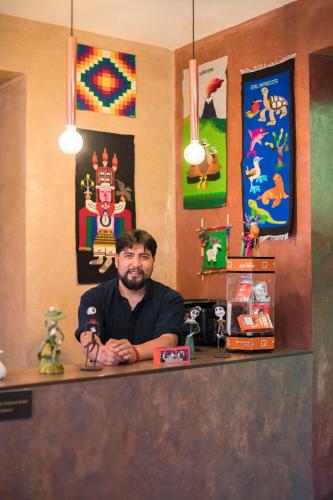 a man sitting at a counter in a restaurant at Chakana Hotel Boutique Centro in Quito