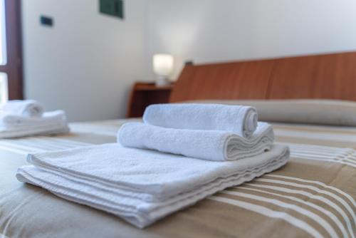 a pile of towels sitting on top of a bed at Pepigall vista mare in Alghero