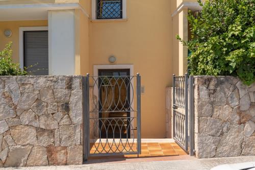 a gate in front of a house with a stone wall at Pepigall vista mare in Alghero