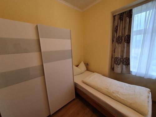 a small room with a bed and a window at Appartement zur Post in Ferlach