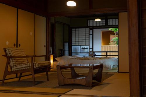 Habitación con cama, mesa y sillas. en Itsumoya, en Miyajima