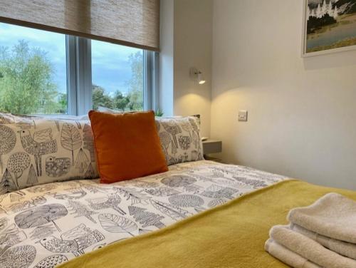 紐馬基特的住宿－72 Ashley Road，一间卧室配有一张带橙色枕头的床