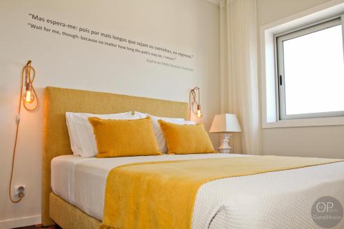 a bedroom with a bed with yellow sheets and a window at 115 OPorto Guest House in Porto