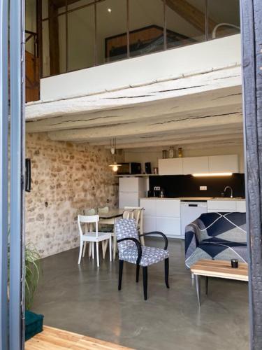 un salon avec une table et des chaises et une cuisine dans l'établissement Les gites de la Vallée Noire, à La Châtre