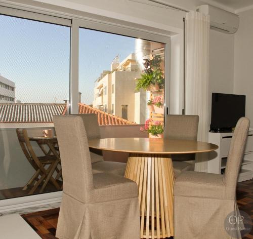 a dining room with a table and chairs and a balcony at 115 OPorto Guest House in Porto