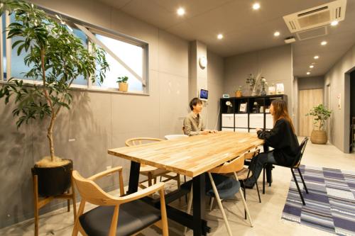 two women sitting at a table in a restaurant at Hostel STAND BY ME in Fukuoka