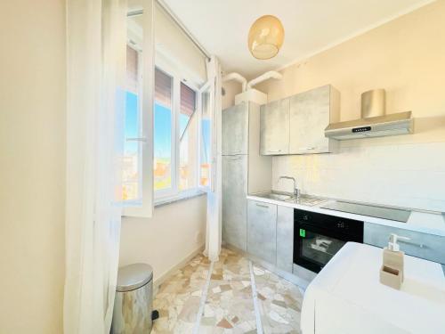 eine weiße Küche mit einem Waschbecken und einem Fenster in der Unterkunft Suite Astraldi - a 2 minuti dall'Ariston in Sanremo