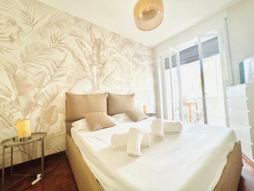 ein Schlafzimmer mit einem großen weißen Bett mit einer tropischen Tapete in der Unterkunft Suite Astraldi - a 2 minuti dall'Ariston in Sanremo