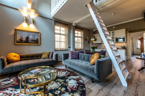 a living room with couches and a staircase at Mondragon in Zierikzee