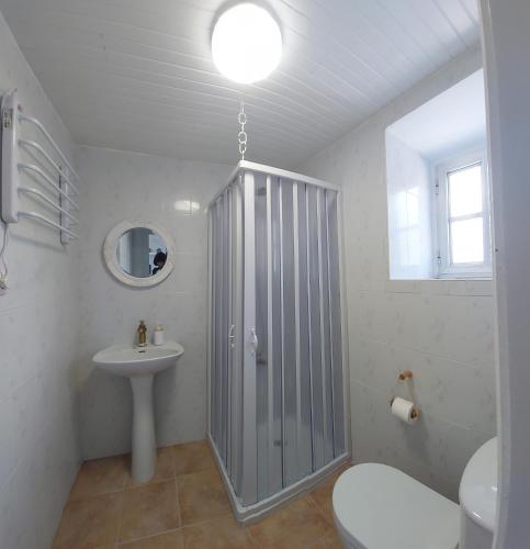a bathroom with a shower and a sink and a toilet at Villa Flor Armenteira in Armentera