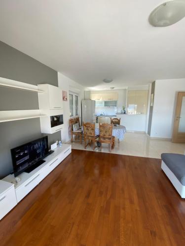 un soggiorno con pavimento in legno massello e una cucina di Apartman Mila a Kaštela (Castelli)
