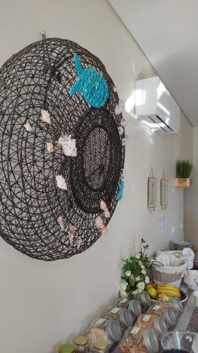 a wire basket hanging from a wall with food at Alojamento Local Verde e Mar in Comporta