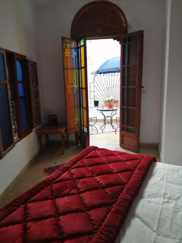 ein Schlafzimmer mit einem Bett und einer offenen Tür in der Unterkunft Riad Siham in El Jadida
