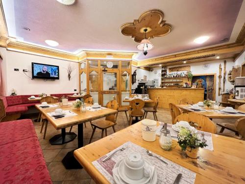 um restaurante com mesas e cadeiras de madeira em Garni Francescato em Livigno