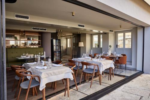 um restaurante com mesas e cadeiras num quarto em Martis Forum Heritage Hotel & Residence em Porec