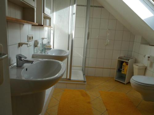 La salle de bains est pourvue de 2 lavabos et de toilettes. dans l'établissement Radlerquartier Edendorf, à Itzehoe