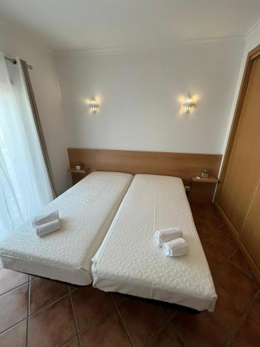 a bedroom with a bed with two towels on it at Parra Home Holidays - Close to Galé Beach in Guia