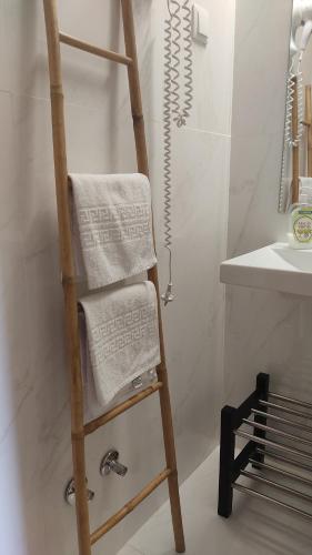 - une échelle en bois avec des serviettes dans la salle de bains dans l'établissement Green & Sea Comporta Retreat, à Comporta
