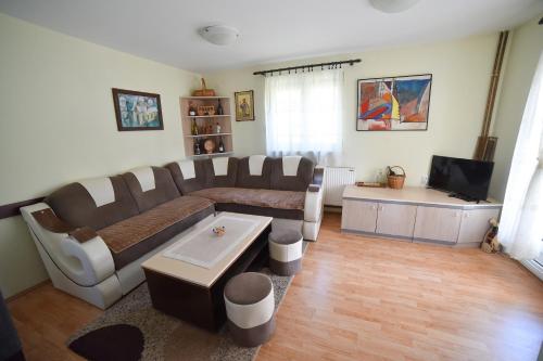 uma sala de estar com um sofá e uma televisão em Vila ZLATNI BOR em Zlatibor