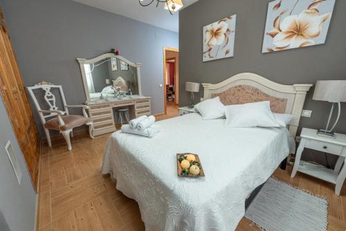Dormitorio con cama con espejo y bandeja de fruta. en Los Valles & Spa, en Pepino