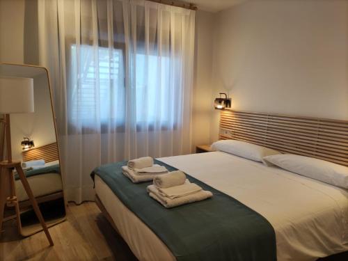 een slaapkamer met 2 handdoeken op een bed met een raam bij tiu Enrique 5 in Cangas de Onís