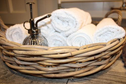 a basket filled with towels on a table at Chambre d'hôtes Les Magnolias in Pontpierre