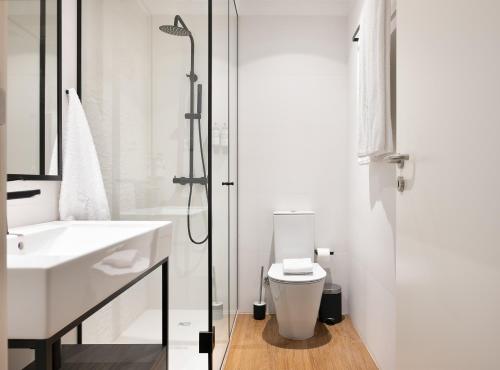 a bathroom with a toilet and a sink and a shower at Catarina Serviced Apartments in Porto