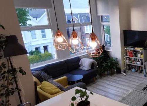 - un salon avec un canapé bleu et quelques lumières dans l'établissement Entire 1-Bed Apartment in London Haringey, à Londres