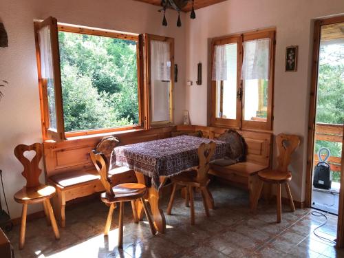 comedor con mesa, sillas y ventana en S.Stefano d’Aveto: relax in montagna, en Santo Stefano dʼAveto