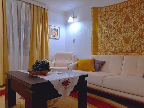 a living room with a white couch and a table at Mountaintop hostel apartments - Hostel Kvish^Khedi in K'vishkhet'i