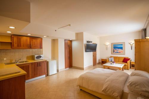 een slaapkamer met een bed en een keuken met een wastafel bij Marom Hotel in Haifa
