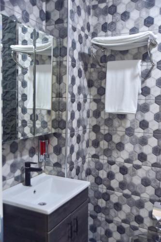 a bathroom with a sink and a mirror and towels at Noya Köşk Otel in Adalar