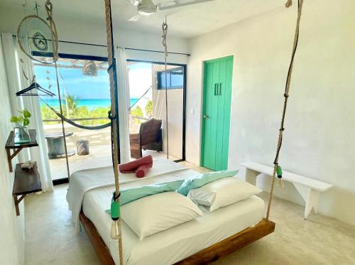 a bedroom with a bed and a chair at LunArena Boutique Beach Hotel Yucatán Mexico in El Cuyo