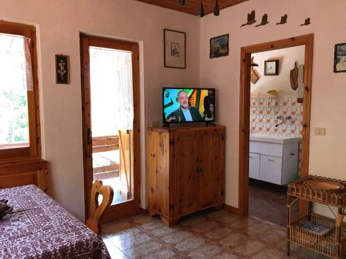 sala de estar con TV en un armario de madera en S.Stefano d’Aveto: relax in montagna, en Santo Stefano dʼAveto