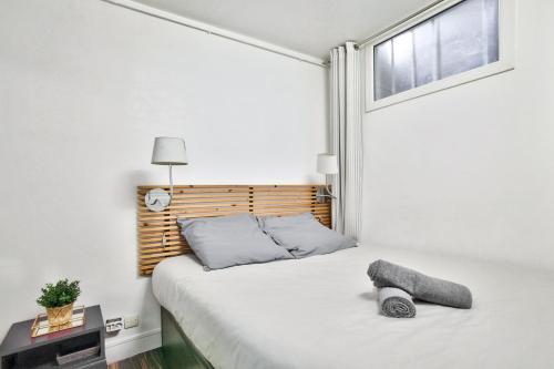 una camera con un letto bianco e una finestra di 1 Bedroom Le Marais Temple a Parigi