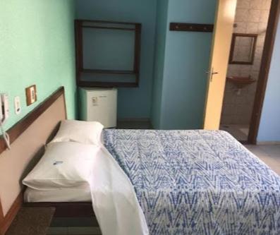 a hospital room with a bed and a television at Hotel Fênix in Salvador