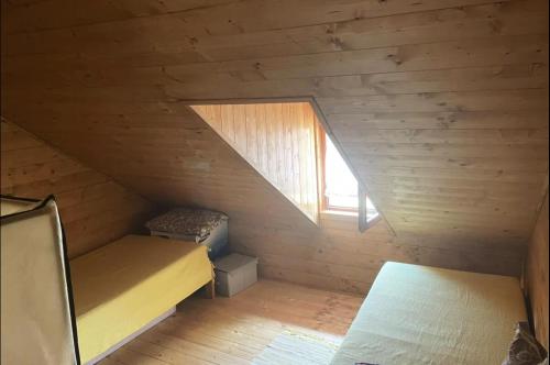 a small attic room with a bed and a window at Kremanski čardak in Kremna