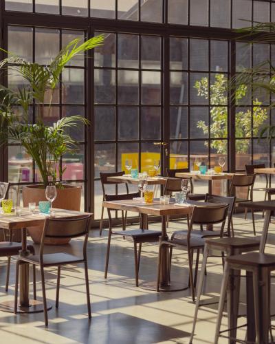 a restaurant with tables and chairs and windows at Locanda Cossetti Ranch Winery in Incisa Scapaccino