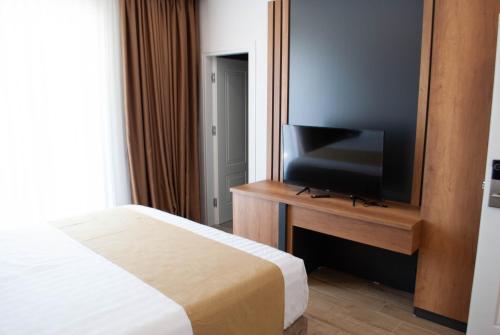 a bedroom with a bed and a flat screen tv at Hilal Palace - Halal in Golem