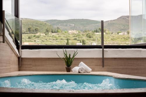 a jacuzzi tub in a room with a large window at Hotel La Sitja - Adults only in Benisoda