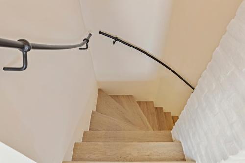 a staircase in a house with a metal hand rail at Huis Potaerde, vakantiewoning op boerderij - luxe landhuis nabij Brussel in Merchtem