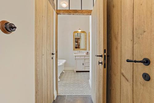 a bathroom with a white tub and a sink at Huis Potaerde, vakantiewoning op boerderij - luxe landhuis nabij Brussel in Merchtem