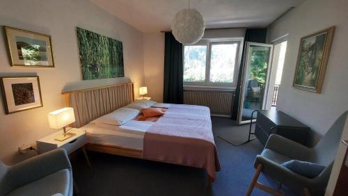 - une chambre avec un lit et deux chaises dans l'établissement Hiša ob jezeru - House by the Lake, à Kranjska Gora