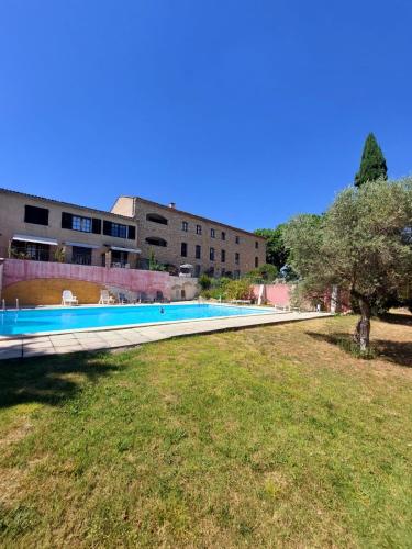 une piscine devant un immeuble dans l'établissement Logement d'exception près du Colorado provencal dans une résidence au calme avec piscine offrant une vue imprenable sur le Luberon depuis sa terrasse, à Viens
