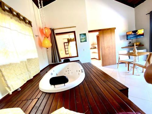a room with a bath tub on a wooden floor at Residencial Villa Cris in Bertioga
